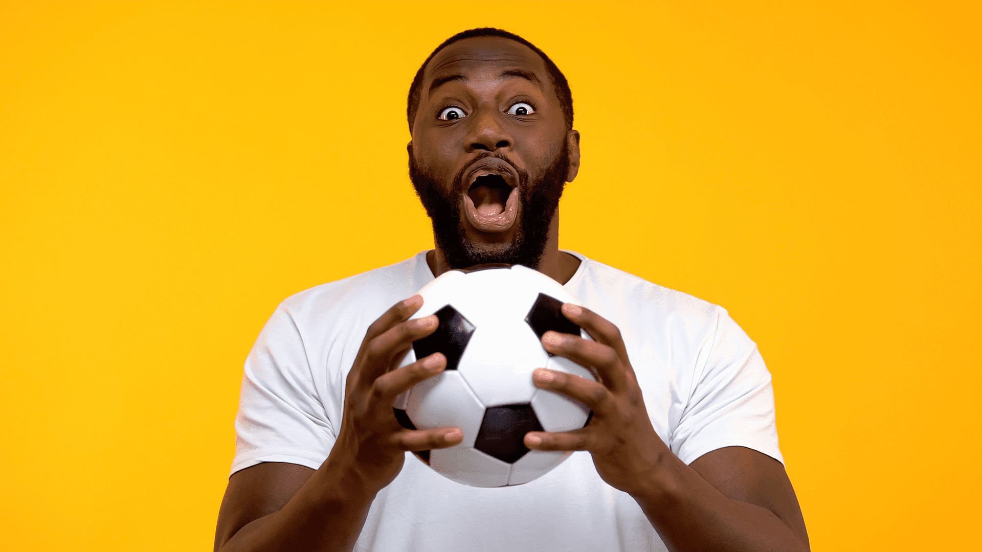black person holding a soccer ball with yellow background